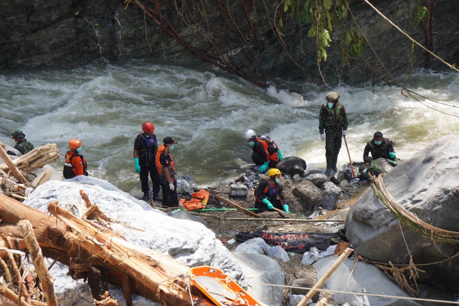 Pembersihan matrial longsoran oleh tim  di aliran jembatan kembar.